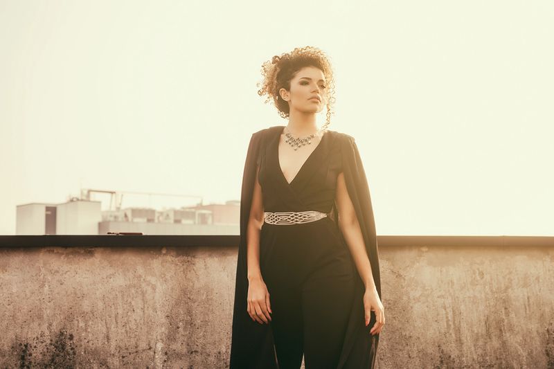 Beautiful and elegant woman standing in the sunlight on rooftop