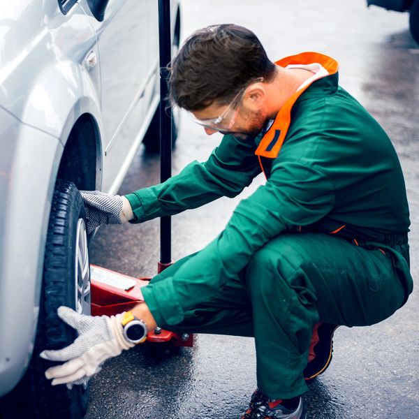 a black mechanic smiling and doing disc skeeming