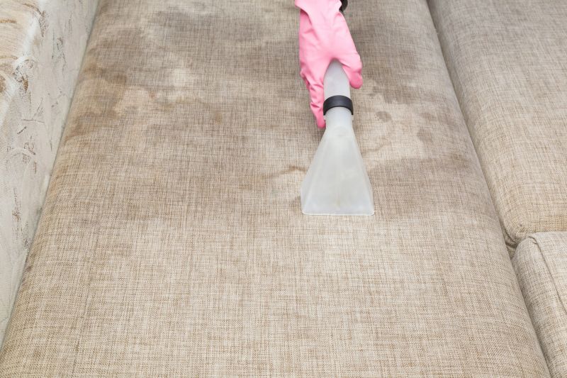 Dry cleaner's employee hand cleaning dirty sofa with professionally extraction method. Before and after. Textile upholstered furniture. Early spring regular cleanup. Commercial cleaning company.