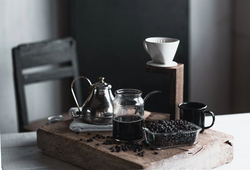 coffee In a glass bottle,Coffee drip,Hand holding a kettle Drip Coffee In the room,Black coffee in glass