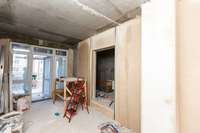 Interior of a room under construction with tools and scaffolding.