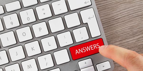 Partial screenshot of a laptop keyboard with a red "ANSWERS" key that someone is about to press.