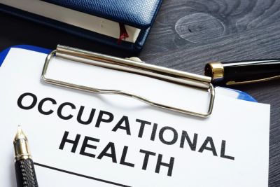 Clipboard with a document titled 'Occupational Health' and a pen on a dark wooden desk.