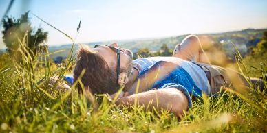 Man relaxing on grass in the sun.