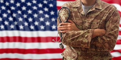 Soldier standing in front of an American flag