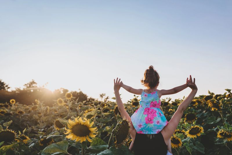A joyful child playing in a sunflower field, captured by KidzPhotos.com