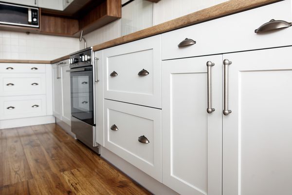 Modern white kitchen cabinets with silver handles.