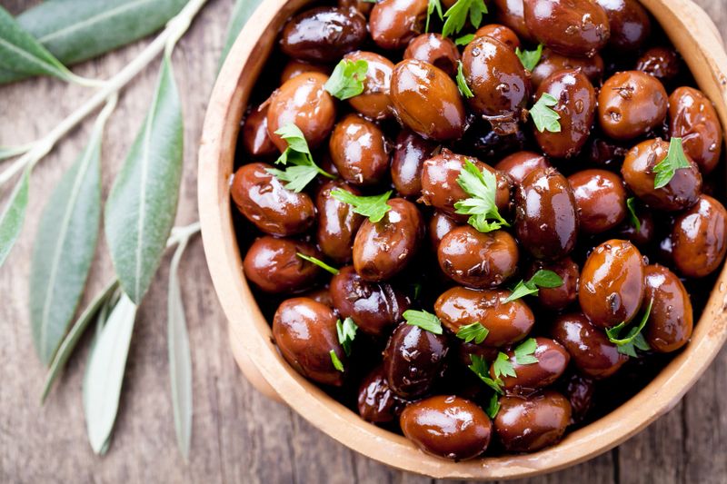 Bowl of black olives with fresh herbs
