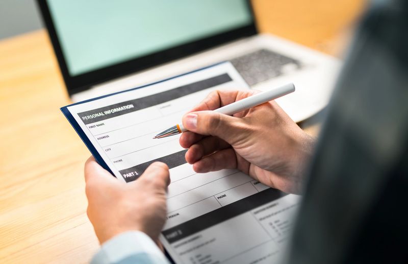 Survey, agreement or application paper. Man writing personal information to questionnaire, contract or home insurance paper. Customer or employee satisfaction poll.