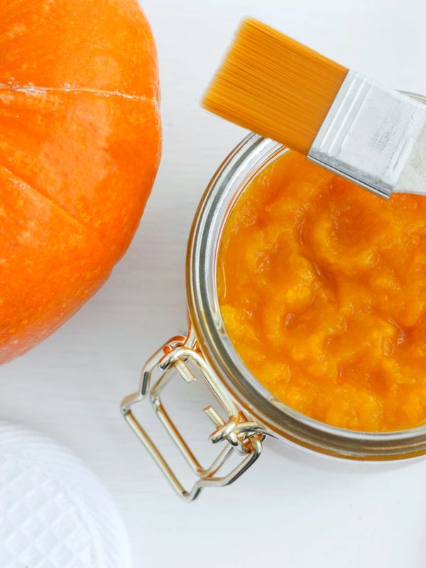 Pumpkin puree in a jar with a brush and a pumpkin.