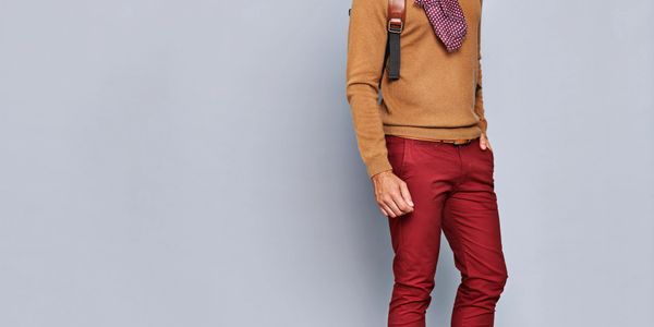 Man dressed in stylish autumn outfit with scarf and glasses.