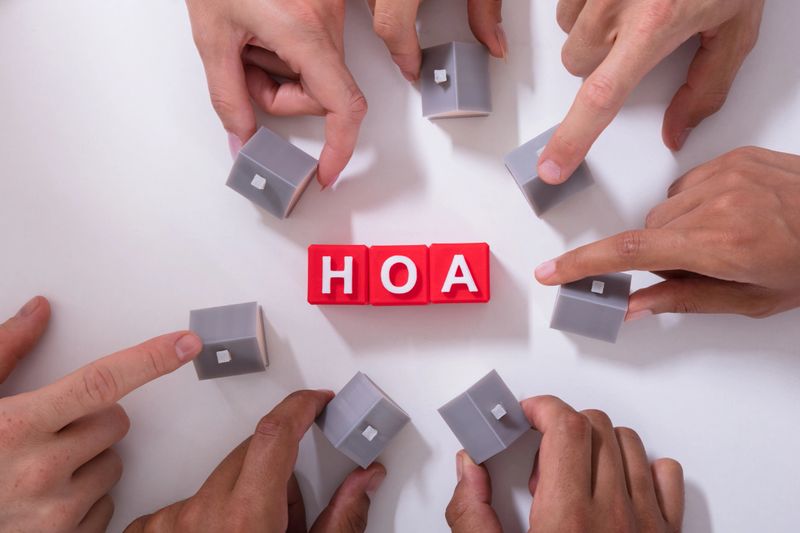 Homeowner Association Blocks Surrounded By People Holding House Model On White Surface
