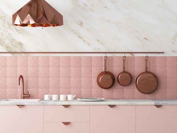 Modern kitchen with pink cabinets and copper accents.