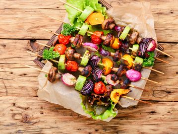 Colorful grilled vegetable skewers with zucchini, mushrooms, peppers, and tomatoes.