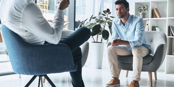 Two men engaged in a serious conversation in a modern office.