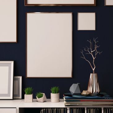 Blank frames and modern decor on a dark wall.
