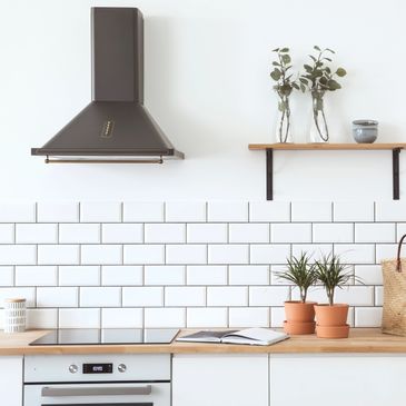 Minimalist kitchen with white subway tiles and wooden accents.