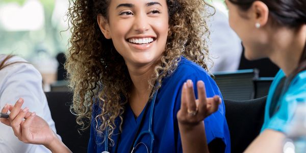 Smiling healthcare professionals engaging in a lively discussion during a meeting.