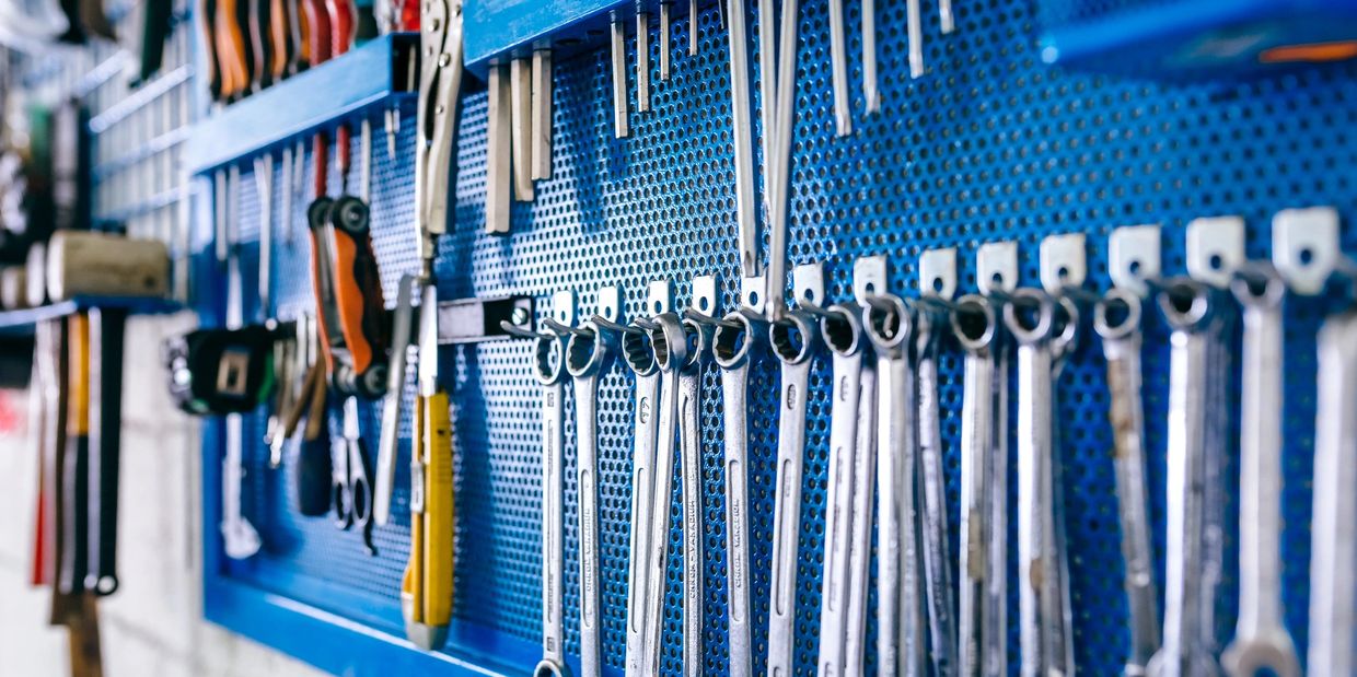 Neatly arranged tools on steel pegboard after professional house cleaning and organization