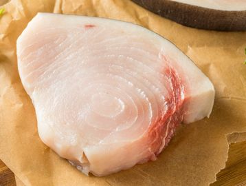 Raw swordfish steak with fresh texture on brown paper.