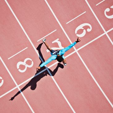 Runner crossing finish line on track.