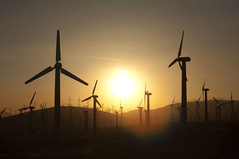 Silhouettes of wind turbines at sunset