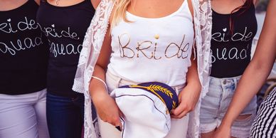 Bride and bridesmaids wearing matching shirts for a bachelorette party.