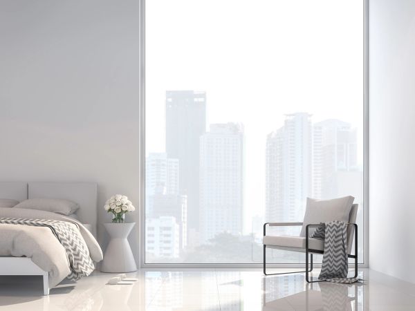 Minimalist bedroom with large window and city view.