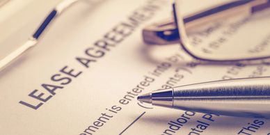 Close-up of a lease agreement document with a pen and glasses.