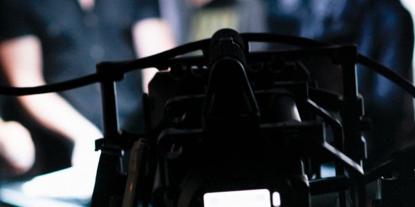 Close-up of camera filming a scene with blurred background.