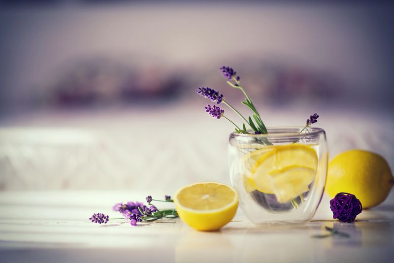 Sprigs of lavender, lemon and a glass of lemon lavender water