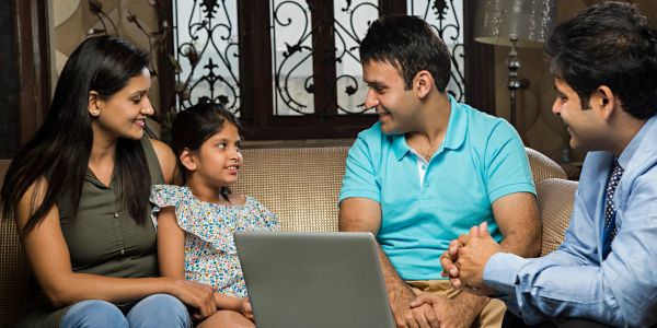 Family with realtor discussing over a laptop.