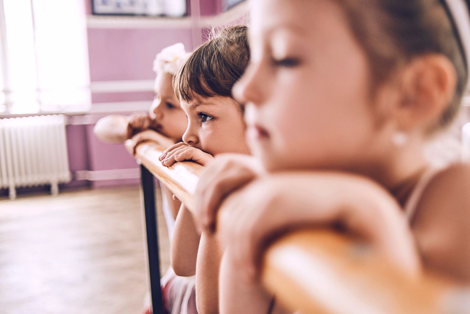 3 little ballerinas peeking over the barre
