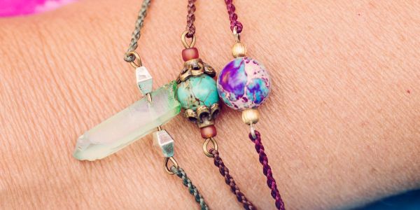 Three colorful beaded bracelets on a wrist.