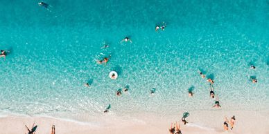 People enjoying a sunny day swimming and relaxing on a clear beach.