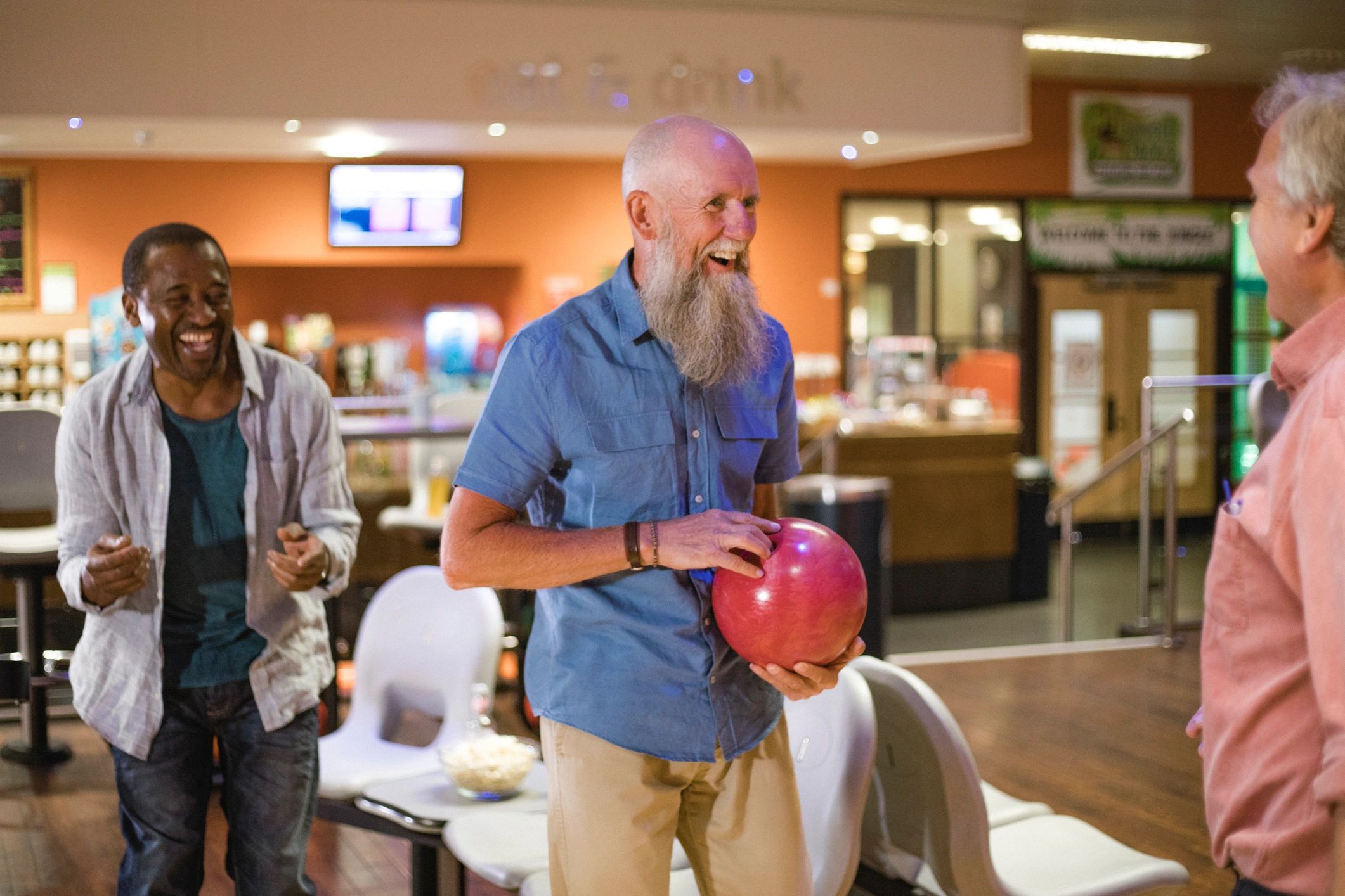 Three men enjoying a game of bowling together.