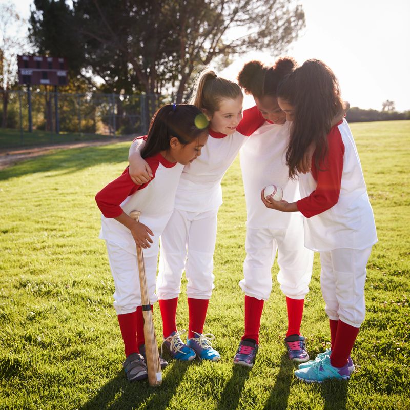 Girl baseball team in a team huddle, motivating before game