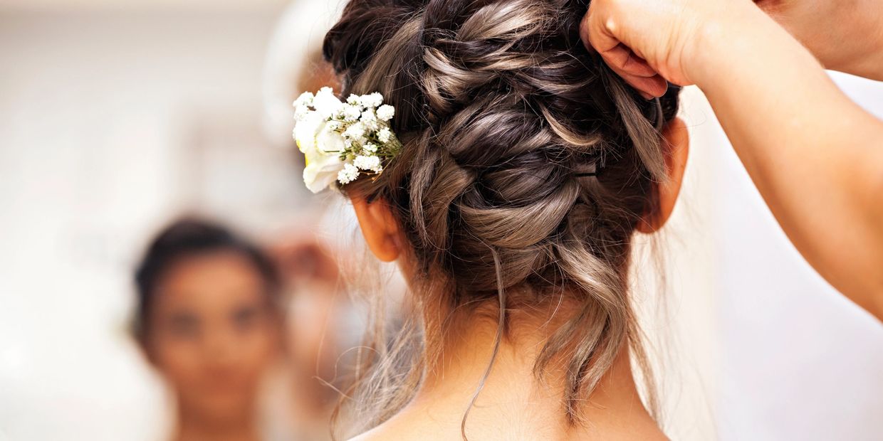 Wedding updo with white flowers and highlights, styled by a hairdresser.