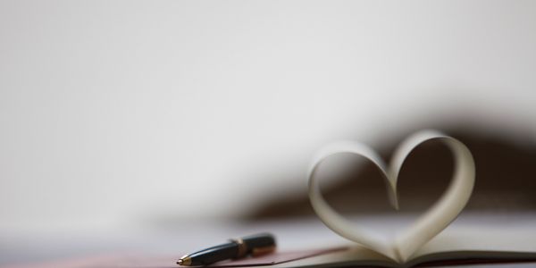 A book shaped like a heart and a pen