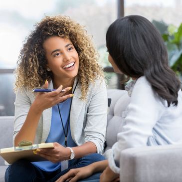 Two women having a friendly conversation indoors.