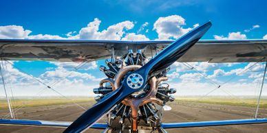 Close-up of a vintage airplane propeller against a bright blue sky.