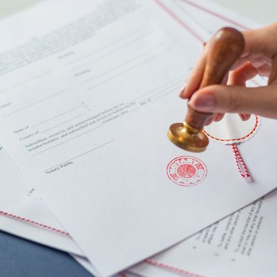 Hand stamping a legal document with a notary seal.