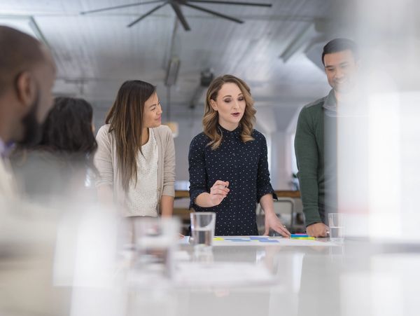 A group of diverse colleagues collaborating around a table in a modern office.