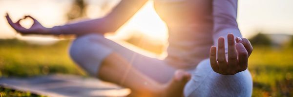 A pregnant woman receiving a back massage from a therapist in a bright room.