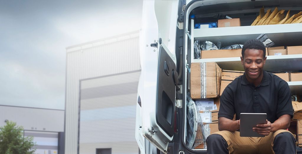 Man sitting on back of supply truck