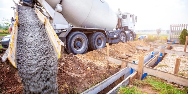 Concrete being poured from a mixer truck at a construction site.
