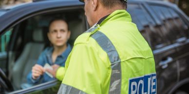 Police officer talking to a driver in a car.