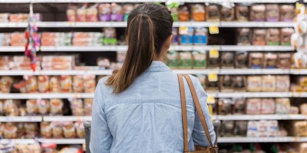 Woman shopping in a grocery store aisle.