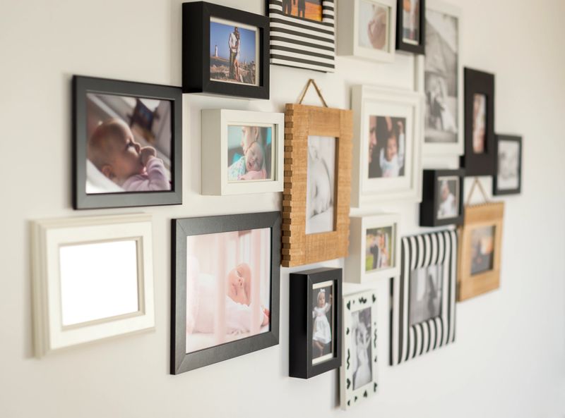 white wall with photos of the family in various photo frames