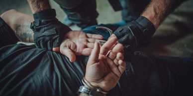Police officer handcuffing a suspect during an arrest.